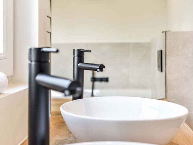 Dual basin bathroom sinks with black faucets