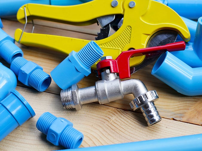Blue PVC pipe fittings and a PVC cutting tool